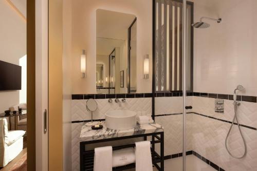 a bathroom with a shower and a sink and a mirror at The Ivens, Autograph Collection in Lisbon