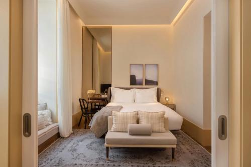 a bedroom with a bed and a chair at The Ivens, Autograph Collection in Lisbon
