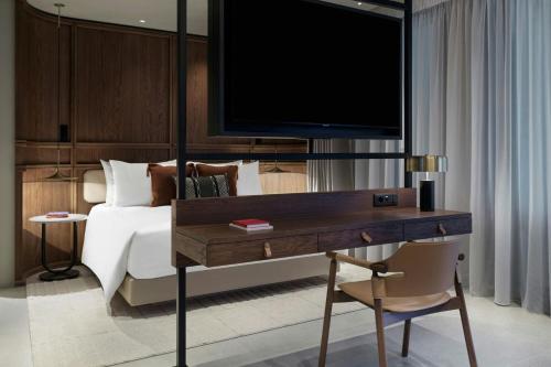 a bedroom with a bed and a desk with a television at MonAsty, Thessaloniki, Autograph Collection in Thessaloniki