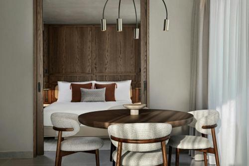 a bedroom with a bed and a table and chairs at MonAsty, Thessaloniki, Autograph Collection in Thessaloniki