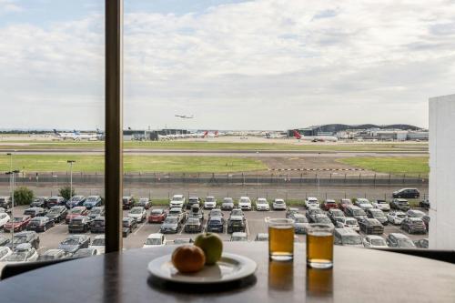 a table with a plate of fruit and two glasses of beer at Renaissance London Heathrow Hotel in Hillingdon