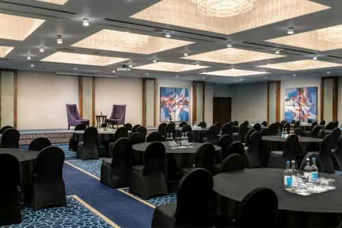 a conference room with tables and chairs and purple chairs at Renaissance London Heathrow Hotel in Hillingdon