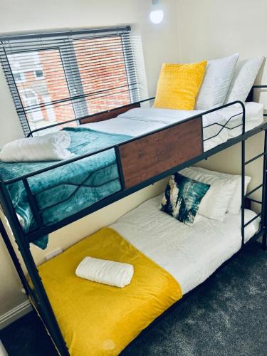 two bunk beds in a room with a window at Spacious 3BR Home in Colchester, with Private Parking in Colchester