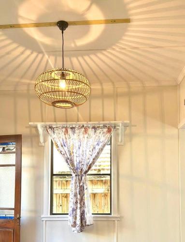 a ceiling fan and a chandelier in a room with a window at Peaceful holiday home in Margate Redcliffe in Redcliffe