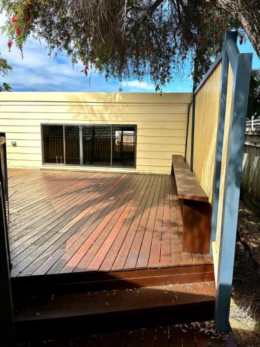 a wooden deck with a bench in front of a building at Peaceful holiday home in Margate Redcliffe in Redcliffe