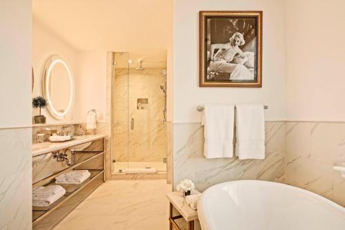 a white bathroom with a tub and a shower at The Historic Cavalier Hotel and Beach Club Autograph Collection in Virginia Beach