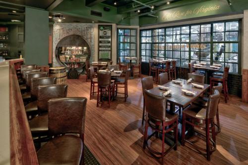a restaurant with tables and chairs and a bar at The Historic Cavalier Hotel and Beach Club Autograph Collection in Virginia Beach