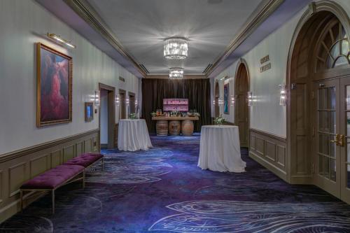 a corridor with two tables in a room at The Historic Cavalier Hotel and Beach Club Autograph Collection in Virginia Beach