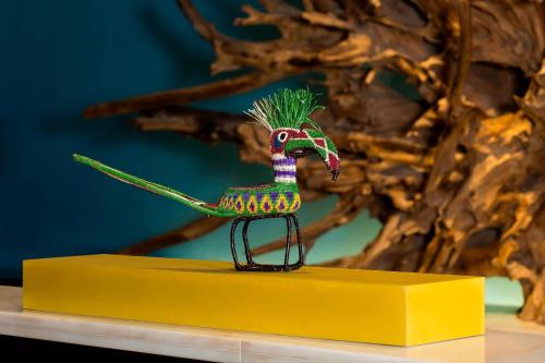 a small toy bird sitting on a yellow shelf at The Buenaventura Golf & Beach Resort, Autograph Collection in Playa Blanca