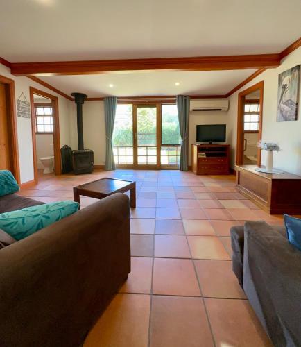 a living room with a couch and a tv at Wild Hearts Cottage in Wallaroo