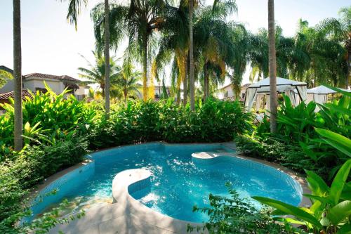 a pool in the middle of a yard with palm trees at The Buenaventura Golf & Beach Resort, Autograph Collection in Playa Blanca