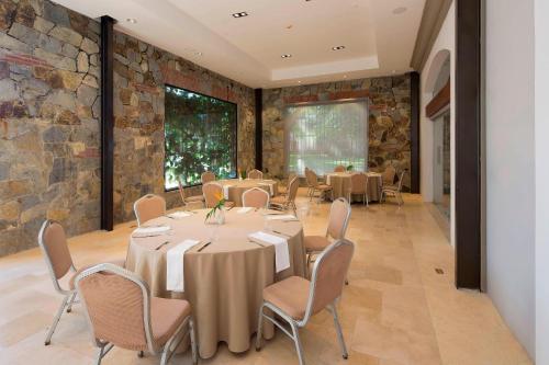a conference room with tables and chairs and a stone wall at The Buenaventura Golf & Beach Resort, Autograph Collection in Playa Blanca