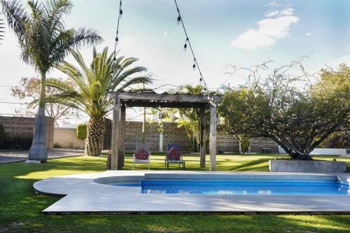 Una piscina en un patio con un cenador. en Villas ARVEM 1, en Atlixco