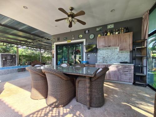 a kitchen with a table and chairs and a ceiling fan at SB Holiday Resort Chiang Mai - Villa Sofia in Chiang Mai