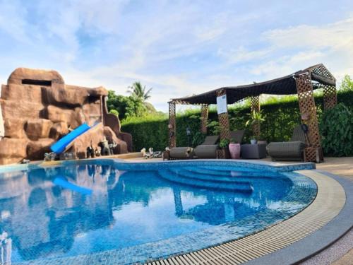 a pool in a resort with a water slide at SB Holiday Resort Chiang Mai - Villa Sofia in Chiang Mai