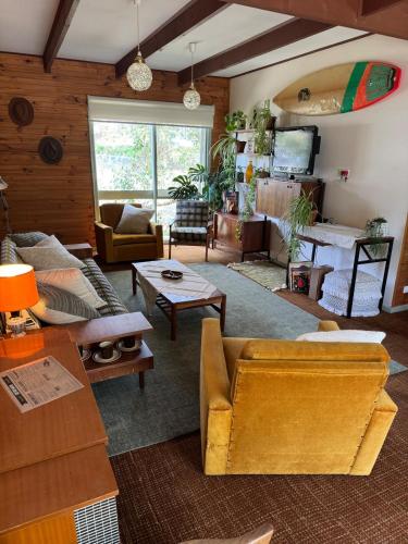 a living room with couches and tables in a room at Golden Days Shack in Jan Juc, Great For Surfers, Family-Friendly, 4-Min Walk to Beach in Torquay