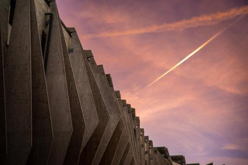 a building with a contrail in the sky at COMO Alpina Dolomites in Alpe di Siusi