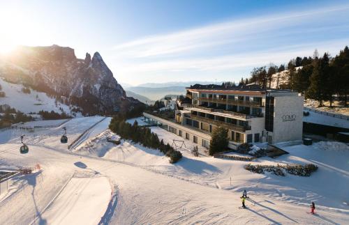 a building on a ski slope in the snow at COMO Alpina Dolomites in Alpe di Siusi