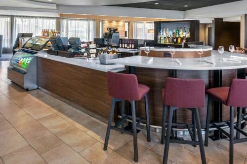 a bar with red chairs in a hotel room at Courtyard Newark Liberty International Airport in Newark