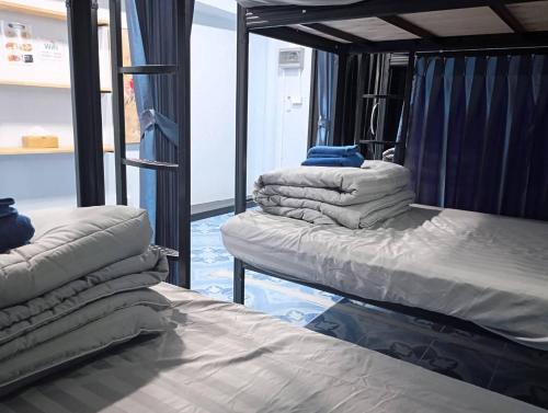 two bunk beds in a room with blue floors at SK Hometel Samui Airport in Bang Rak Beach