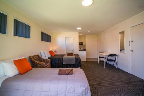 a hotel room with a bed and a table at Colonial On Gladstone Motel in Gisborne