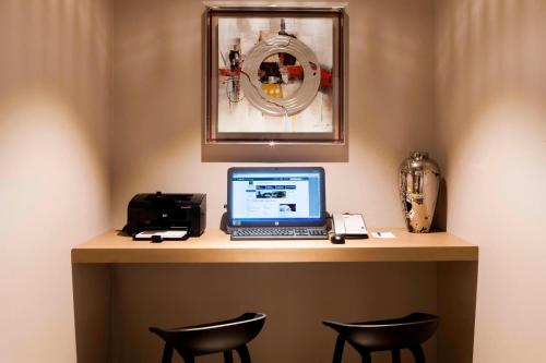 a desk with a laptop computer and two chairs at AC Hotel by Marriott Paris Le Bourget Airport in Le Bourget