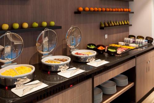 a buffet line with bowls of food in a restaurant at AC Hotel by Marriott Paris Le Bourget Airport in Le Bourget