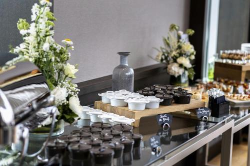 a table with cupcakes and a vase and flowers at AC Hotel by Marriott Paris Le Bourget Airport in Le Bourget
