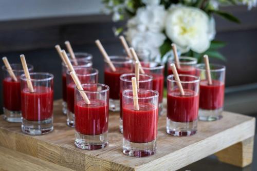 a group of glasses filled with red liquid on a table at AC Hotel by Marriott Paris Le Bourget Airport in Le Bourget