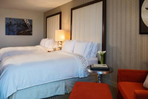 a hotel room with a large white bed and a red couch at Renaissance Newark Airport Hotel in Elizabeth