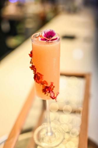 a drink in a glass with a flower on it at AC Hotel by Marriott San Jose Escazu in San José