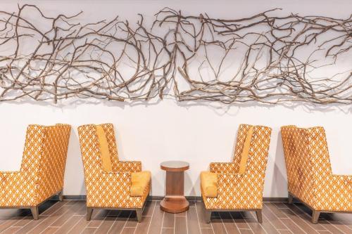 a group of chairs in a room with a painting on the wall at Courtyard by Marriott Thousand Oaks Agoura Hills in Agoura Hills