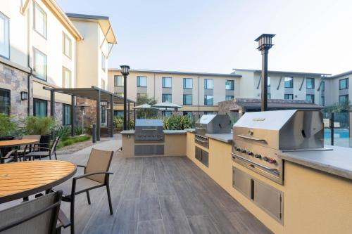 an outdoor kitchen with tables and chairs and a building at Courtyard by Marriott Thousand Oaks Agoura Hills in Agoura Hills