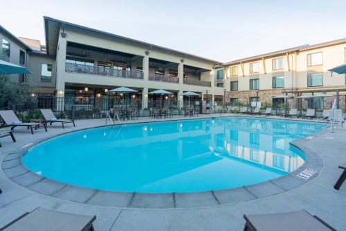 a large pool at a hotel with tables and chairs at Courtyard by Marriott Thousand Oaks Agoura Hills in Agoura Hills