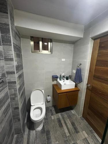 ein Badezimmer mit Toilette und Waschbecken in der Unterkunft Tu guarida in Santo Domingo