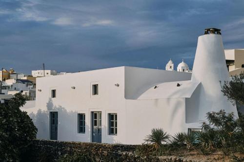 a white house with a lighthouse on top of it at Vedema, a Luxury Collection Resort, Santorini in Megalokhori