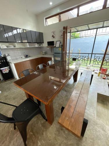 a kitchen with a wooden table and a table and benches at Cozy Home in Bacolod City near Airport & the Ruins in Bacolod