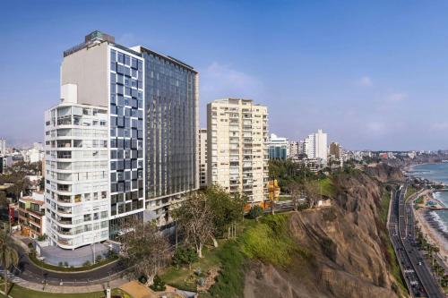 a tall building in a city next to the ocean at AC Hotel by Marriott Lima Miraflores in Lima