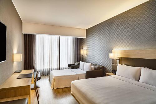 a hotel room with two beds and a desk at AC Hotel by Marriott Lima Miraflores in Lima