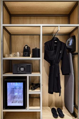 a shelf with a tv and a robe on it at AC Hotel by Marriott Lima Miraflores in Lima