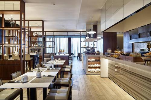 a restaurant with tables and chairs and a kitchen at AC Hotel by Marriott Lima Miraflores in Lima