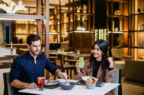 a man and woman sitting at a table eating food at AC Hotel by Marriott Lima Miraflores in Lima