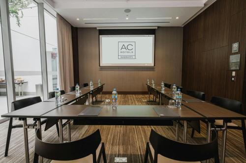 a conference room with tables and chairs and a screen at AC Hotel by Marriott Lima Miraflores in Lima