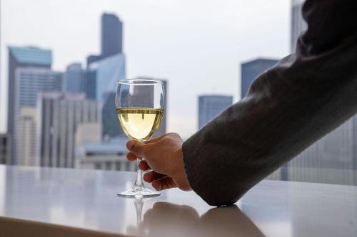 a person holding a glass of white wine at Sheraton Grand Seattle in Seattle