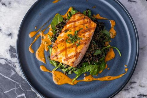 a blue plate with a piece of fish on a salad at Sheraton Grand Seattle in Seattle