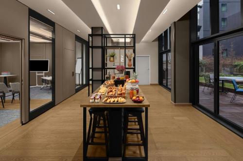 a table with food on it in a room with windows at Courtyard by Marriott Paris Porte de Versailles in Issy-les-Moulineaux