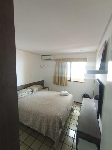 a small bedroom with a bed and a window at Flat hotel number one 403 in São Luís