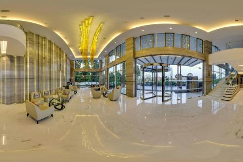 a lobby with couches and chairs in a building at Renaissance Lucknow Hotel, Gomti Nagar in Lucknow