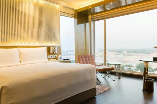a bedroom with a large bed and a large window at Renaissance Lucknow Hotel, Gomti Nagar in Lucknow