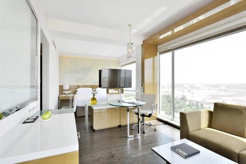 a hotel room with a bed and a couch and a desk at Renaissance Lucknow Hotel, Gomti Nagar in Lucknow